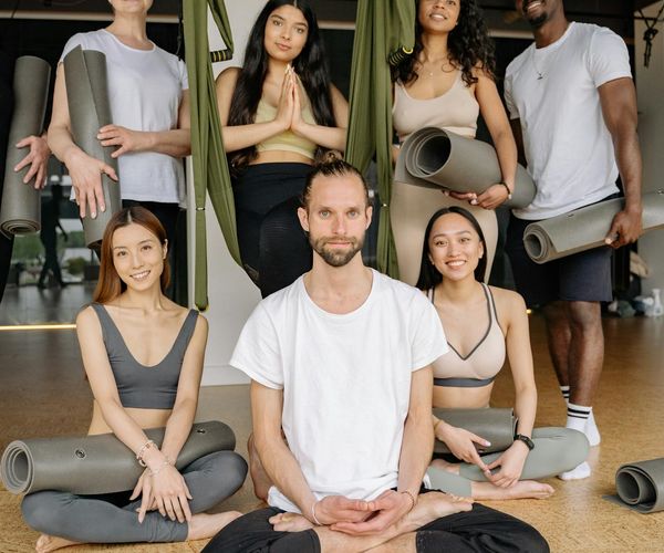 Diverse group of people smiling in a yoga class.